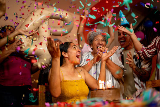 Friends cheering with confetti around a birthday celebration cake during a lively Melbourne party