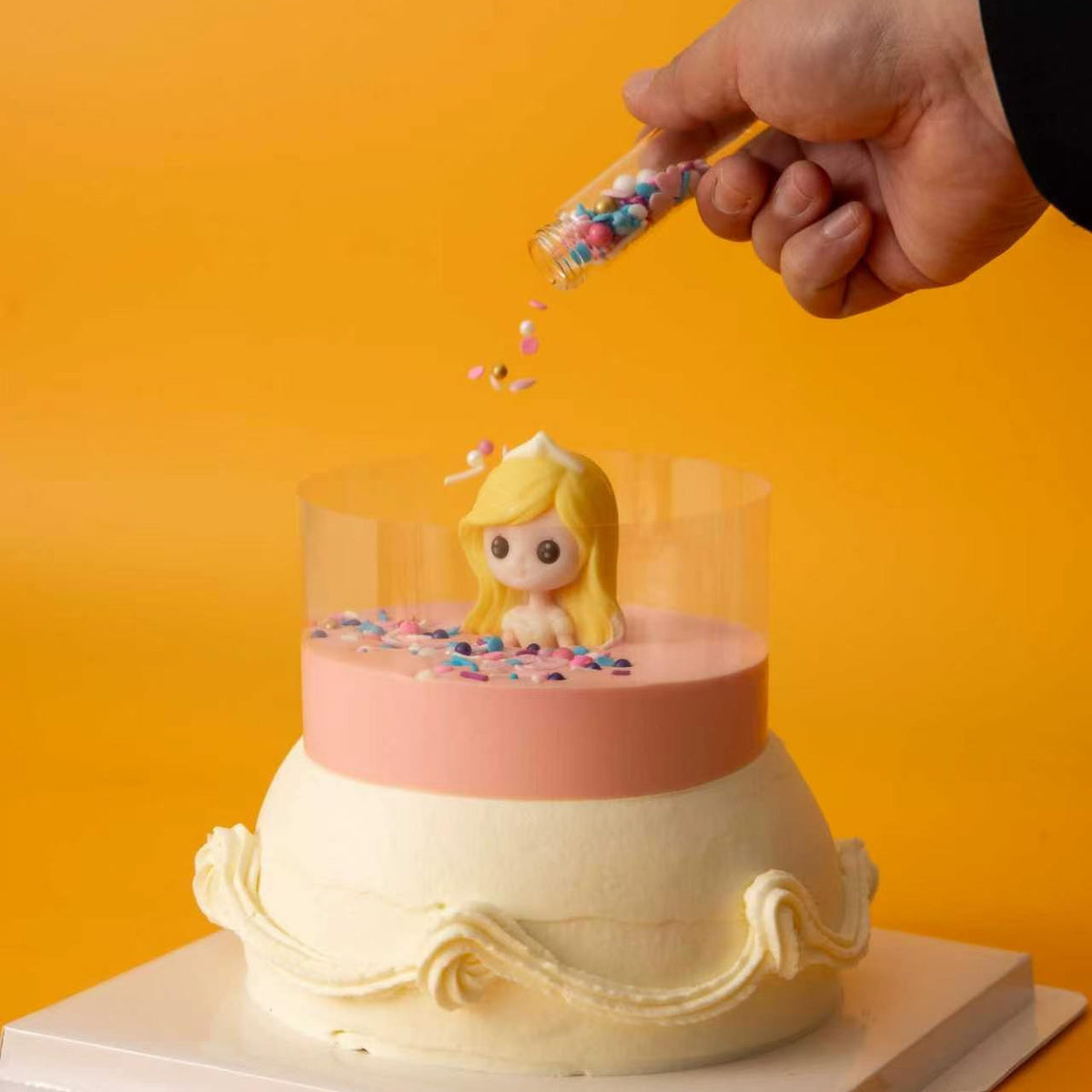 Adding colourful sprinkles to the Pour & Sprinkle Princess Cake